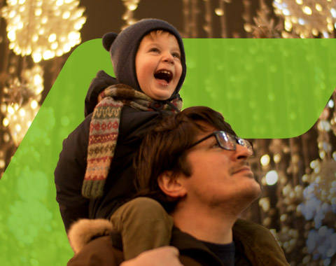 Imagem de um pai com o filho às cavalitas e ambos com um ar muito feliz - Campanha de Natal CGD