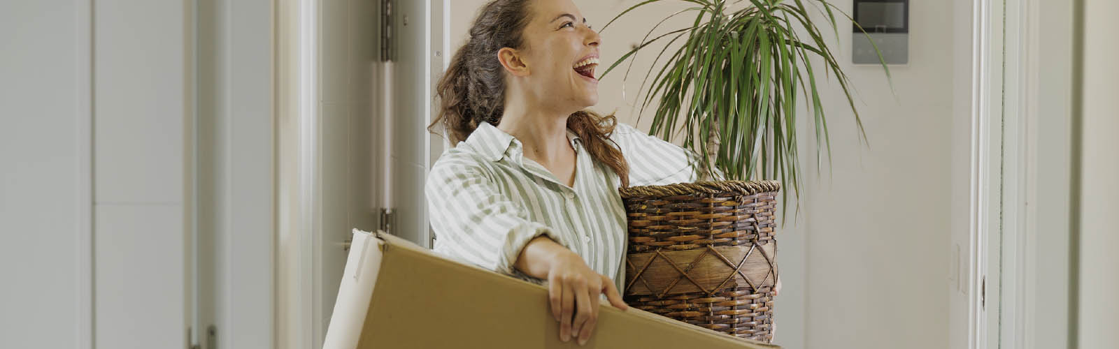Jovem feliz em mudanças pegando em caixotes