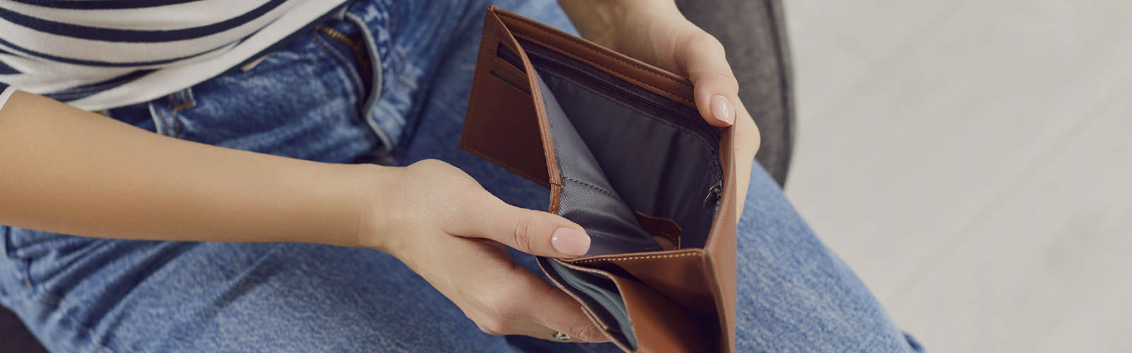 Pessoa abre carteira que está vazia e sem dinheiro