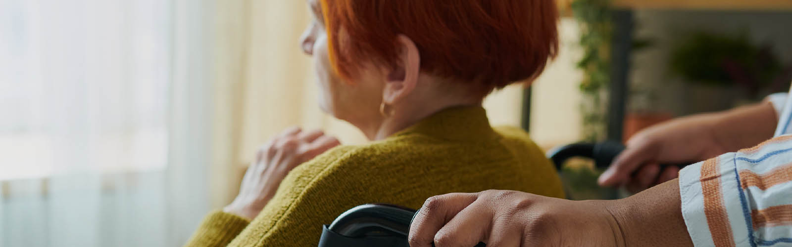 Pessoa  em cadeira de rodas recebe ajuda de alguém