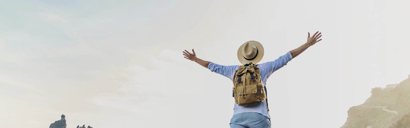 Pessoa de férias levanta os braços com alegria e descontração